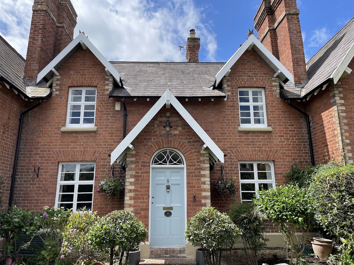Period brick cottage in Chester with freshly painted white gables and a pale blue front door