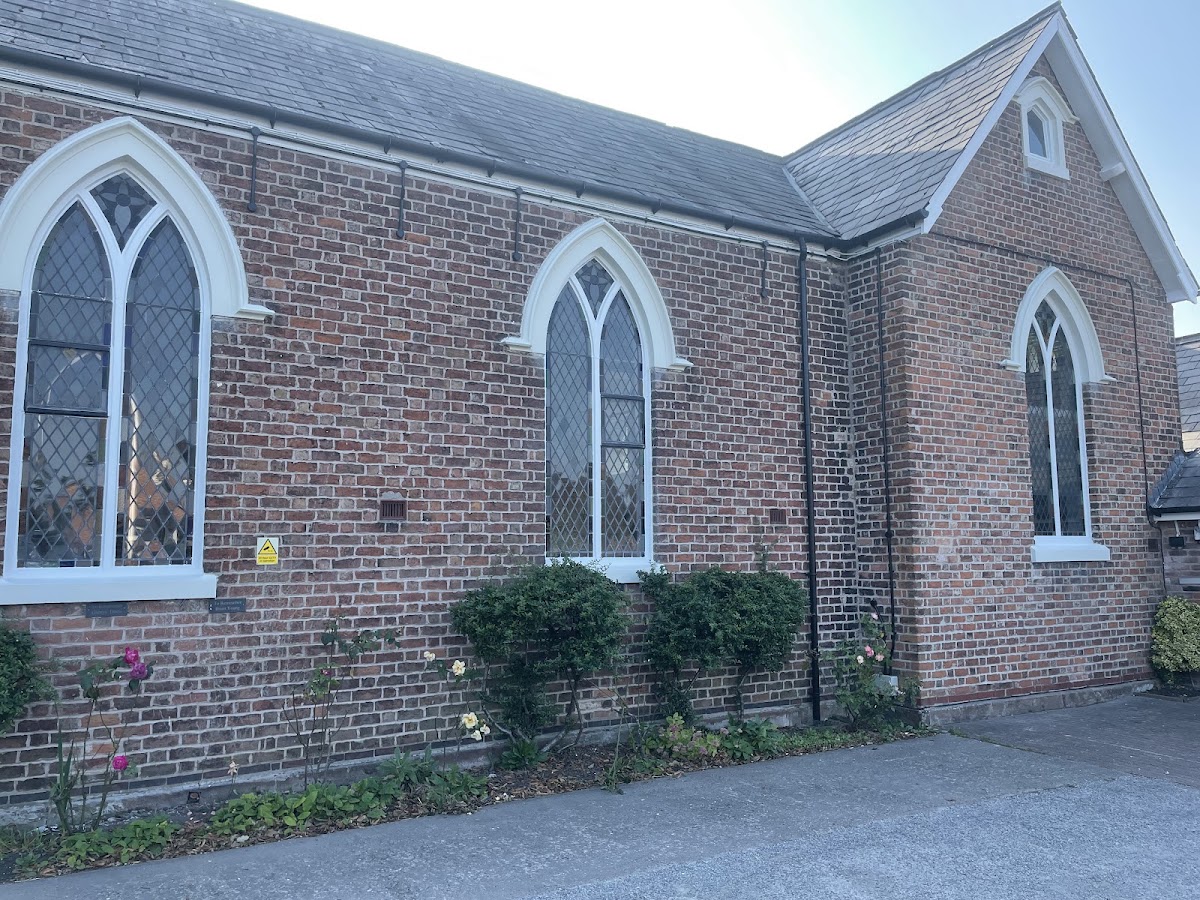 Gothic arched chapel windows repainted crisp white against brickwork