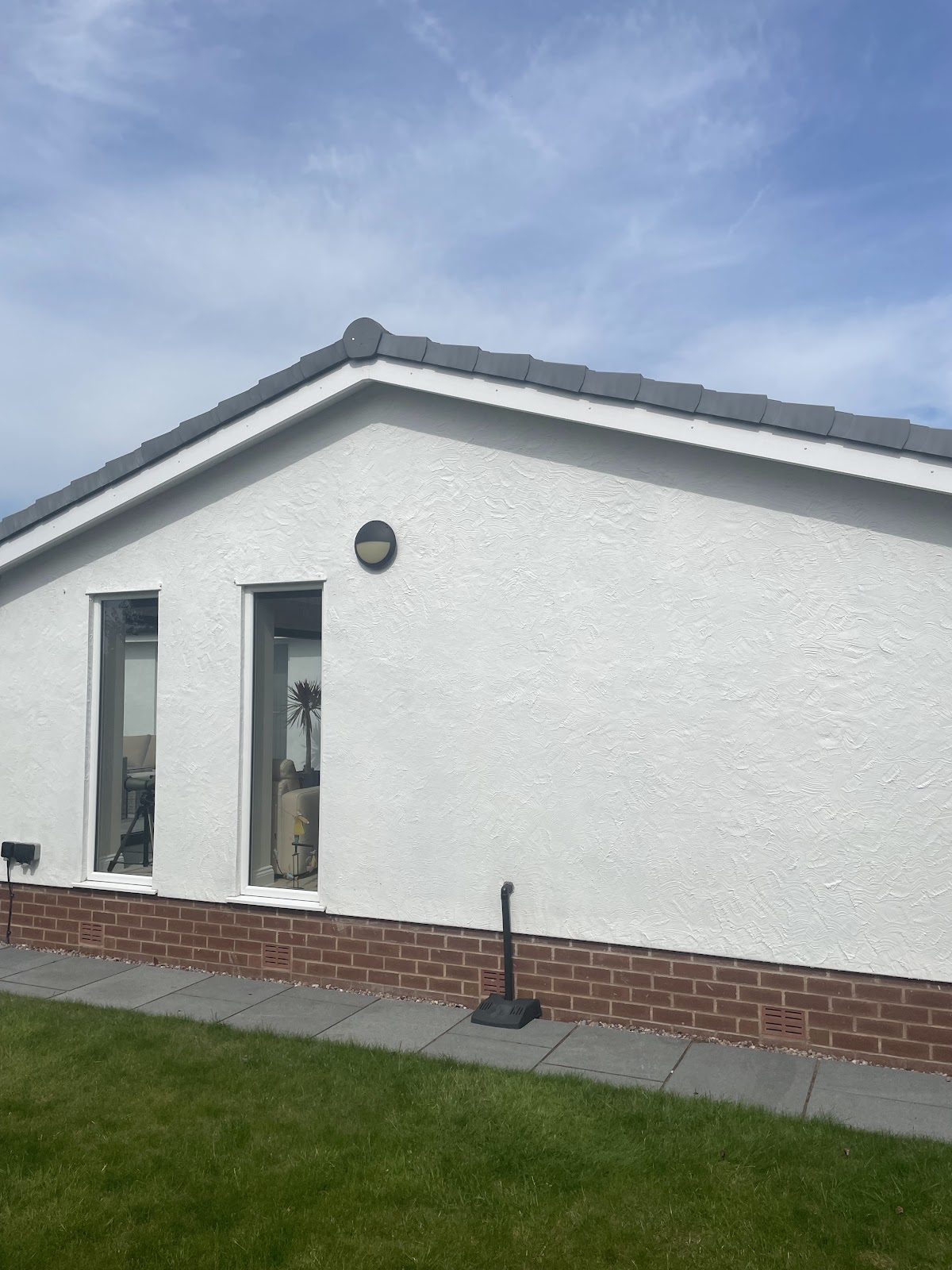White rendered gable end of a bungalow, freshly painted masonry